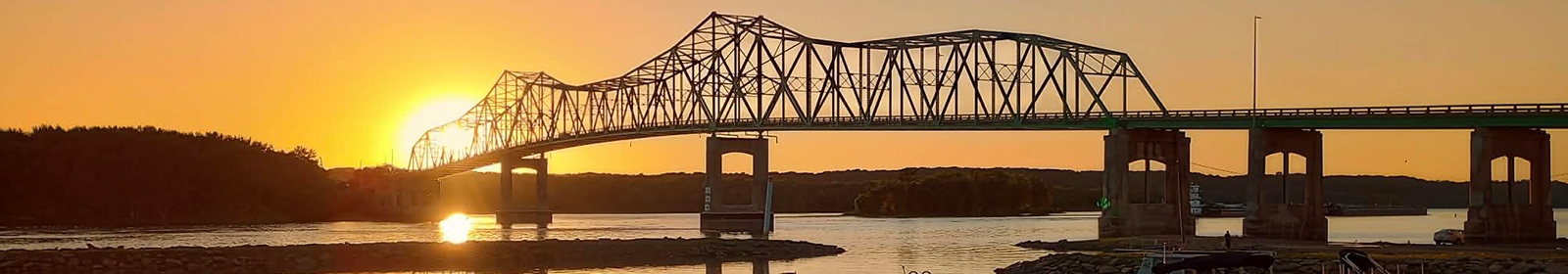 Sunset behind a bridge over the river.